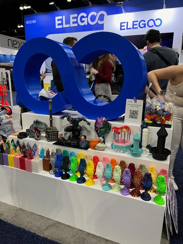 A very colorful display of 3D printed samples is in front of a sign that says Elegoo.